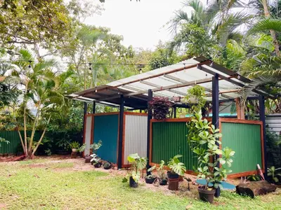 a pergola with potted plants in a yard at Tres Corazones in Carrillo