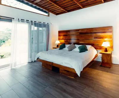 a bedroom with a large bed with a wooden headboard at Luxury Villa Ceibo - Exquisite, Private, Serene in San Mateo