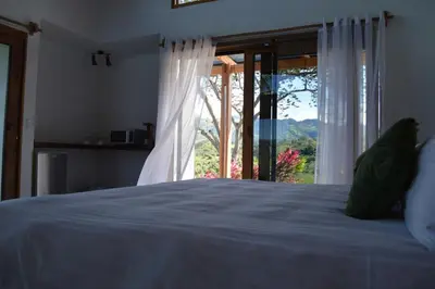 a bedroom with a bed and a large window at Luxury Villa Ceibo - Exquisite, Private, Serene in San Mateo
