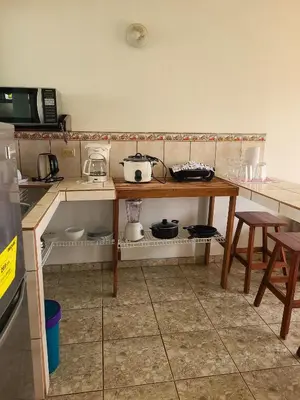 a kitchen with a table with pots and pans on it at Arenal Dreams Apartments in Fortuna