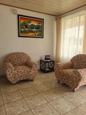 a living room with two chairs and a table at Arenal Dreams Apartments in Fortuna