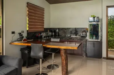 a kitchen with a wooden table and some chairs at Tree of Heaven Lodge in San Isidro