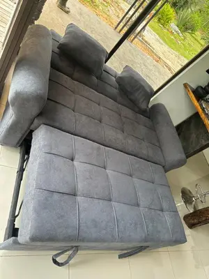 a couch sitting in a living room next to a window at Tree of Heaven Lodge in San Isidro