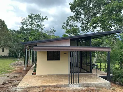 a small house with a black roof at Tree of Heaven Lodge in San Isidro