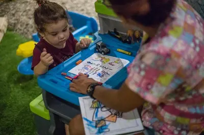 a woman standing next to a little girl in a table at LA DOLCE VITA - on the Beach - Samara in Sámara