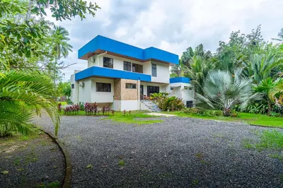 a house with a blue roof at Sleep 11-Beachfront-Pool-Wildlife-100MB -Suites in Parrita