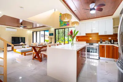 a large kitchen with a table and a dining room at Sleep 11-Beachfront-Pool-Wildlife-100MB -Suites in Parrita