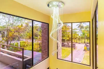 a room with large windows and a chandelier at Sleep 11-Beachfront-Pool-Wildlife-100MB -Suites in Parrita