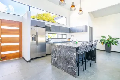 a kitchen with a large island with bar stools at Uvita-Great location-3 bedroom-Private pool-Gated in Uvita