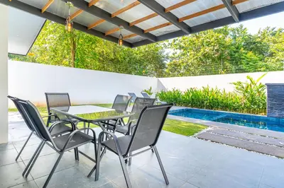 a patio with a table and chairs next to a swimming pool at Uvita-Great location-3 bedroom-Private pool-Gated in Uvita