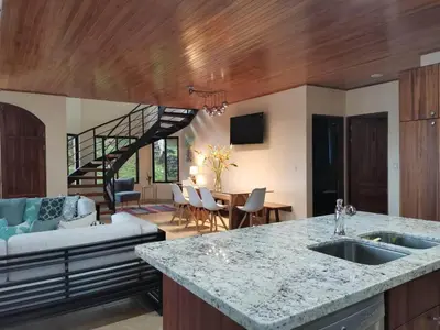 a kitchen with a counter top and a living room at 4 bedroom-sleep 9-private pool-gated-Ojochal in Ojochal