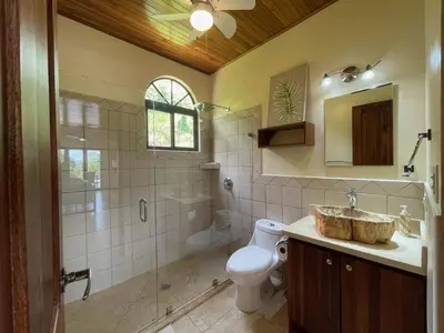 a bathroom with a toilet and a sink and a shower at 4 bedroom-sleep 9-private pool-gated-Ojochal in Ojochal