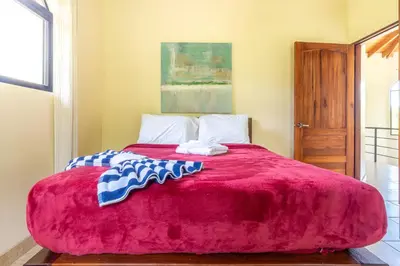 a bedroom with a red bed with two towels on it at 4 bedroom-sleep 9-private pool-gated-Ojochal in Ojochal