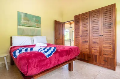 a bedroom with a bed and a wooden cabinet at 4 bedroom-sleep 9-private pool-gated-Ojochal in Ojochal
