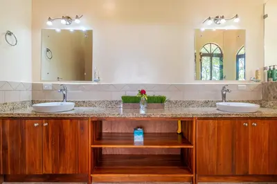 a bathroom with two sinks and two mirrors at 4 bedroom-sleep 9-private pool-gated-Ojochal in Ojochal