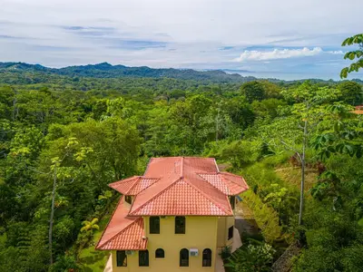 a house with an orange roof in a forest at 4 bedroom-sleep 9-private pool-gated-Ojochal in Ojochal