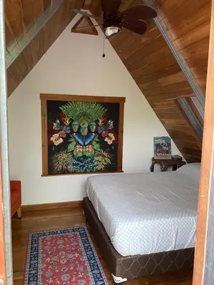 a bedroom with a bed and a painting on the wall at Casa Mariposa, Playa Ostional in Nosara