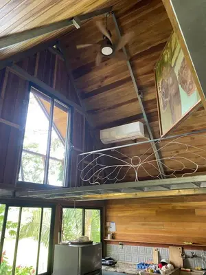a kitchen with wooden walls and windows and a ceiling at Casa Mariposa, Playa Ostional in Nosara