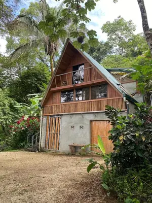 a house with a wooden door and a window at Casa Mariposa, Playa Ostional in Nosara
