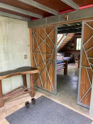 a room with a wooden door and a bench at Casa Mariposa, Playa Ostional in Nosara