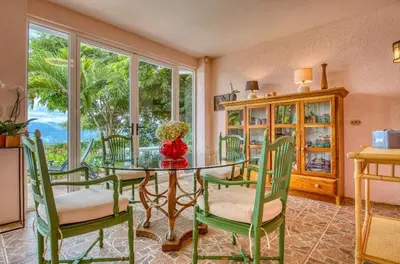 a dining room with a glass table and chairs at Finca Orgánica Sweet Home Mango in San Mateo