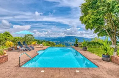 a swimming pool with a view of the mountains at Finca Orgánica Sweet Home Mango in San Mateo