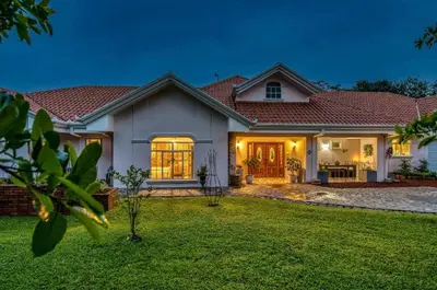 a large white house with a yard at Finca Orgánica Sweet Home Mango in San Mateo