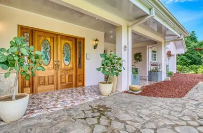 a front door of a house with potted plants at Finca Orgánica Sweet Home Mango in San Mateo