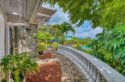 a house with a balcony with a view of a yard at Finca Orgánica Sweet Home Mango in San Mateo