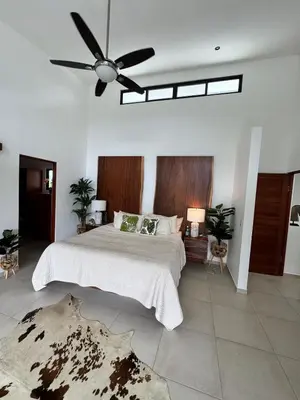 a bedroom with a large bed with a ceiling fan at Villa Montemar Ocean and Mountain Views Elevated 1200 FT with Wifi in Platanillo