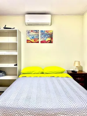 a bedroom with a bed and two paintings on the wall at Villas Arenal Dreams in Palma