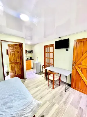 a room with a bed and a table and a tv at Villas Arenal Dreams in Palma