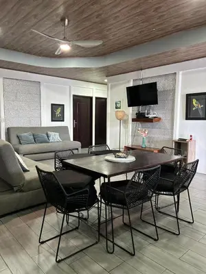 a living room with a table and chairs and a couch at Casa Selva Viva in Uvita