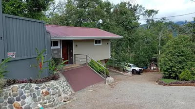 a small house with a garage and a driveway at Magnolia Farm Suites in San Isidro