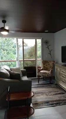 a living room with a couch and a television at Magnolia Farm Suites in San Isidro