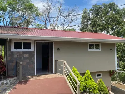 a small house with a red roof at Magnolia Farm Suites in San Isidro