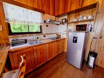 a kitchen with a refrigerator and a sink and a window at House in the Clouds -Monteverde in Tilarán