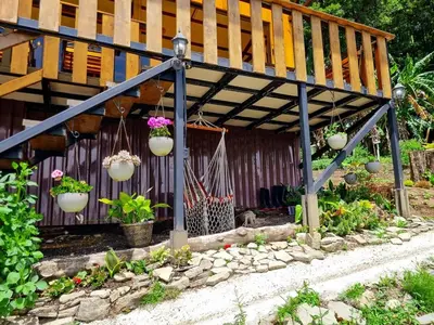 a pergola with potted plants and flowers in a garden at House in the Clouds -Monteverde in Tilarán