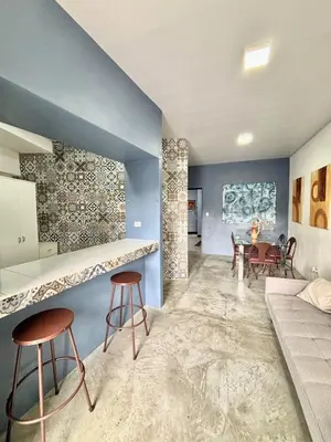a living room with blue walls and stools at Los Yoses Loft - Ideal for Long Stays in San Jose in San José