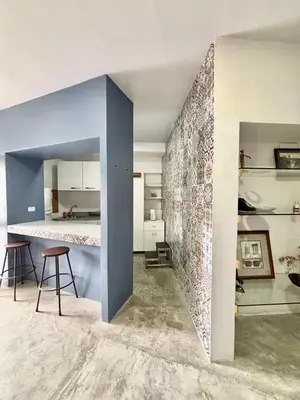 a kitchen and living room with a tile wall at Los Yoses Loft - Ideal for Long Stays in San Jose in San José