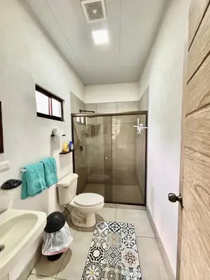 a bathroom with a shower and a toilet and a sink at Los Yoses Loft - Ideal for Long Stays in San Jose in San José
