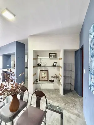 a living room with blue walls and a table and chairs at Los Yoses Loft - Ideal for Long Stays in San Jose in San José