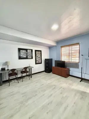 an empty room with a table and chairs and a television at Los Yoses Loft - Ideal for Long Stays in San Jose in San José