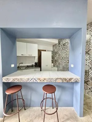 a kitchen with two stools sitting at a counter at Los Yoses Loft - Ideal for Long Stays in San Jose in San José