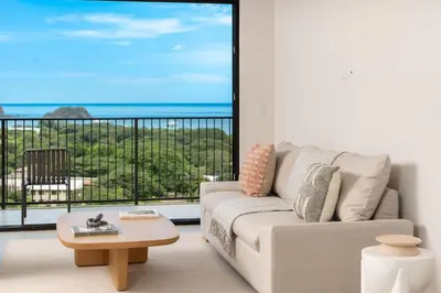 a living room with a couch and a view of the ocean at Cielo de Coco at Naumi, Ocean Views & Beach Club in Sardinal