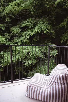 a striped mattress sitting on a balcony with trees at Brisa del Valle at Naumi, Ocean Views & Beach Club in Sardinal
