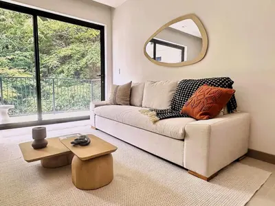 a living room with a couch and a mirror at Brisa del Valle at Naumi, Ocean Views & Beach Club in Sardinal