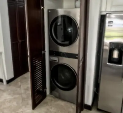 a microwave and a washer and dryer in a room at Luxury Walkout Beachfront Jaco Condo-Sleep 6 in Jacó