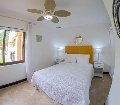 a bedroom with a bed and a ceiling fan at Luxury Walkout Beachfront Jaco Condo-Sleep 6 in Jacó