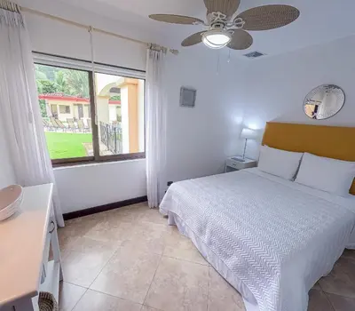 a bedroom with a white bed and a window at Luxury Walkout Beachfront Jaco Condo-Sleep 6 in Jacó